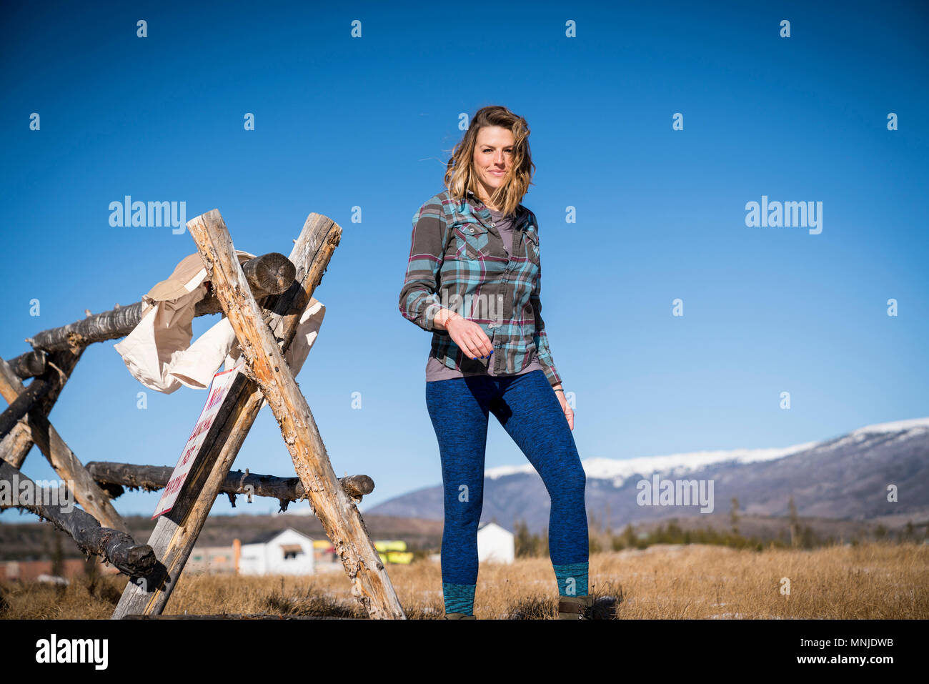 Donna in plaid shirt in piedi in campo Foto Stock