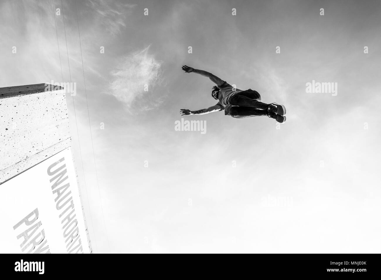 Atleta parco jumping alto gap nel parcheggio in centro a Denver, Colorado, STATI UNITI D'AMERICA Foto Stock