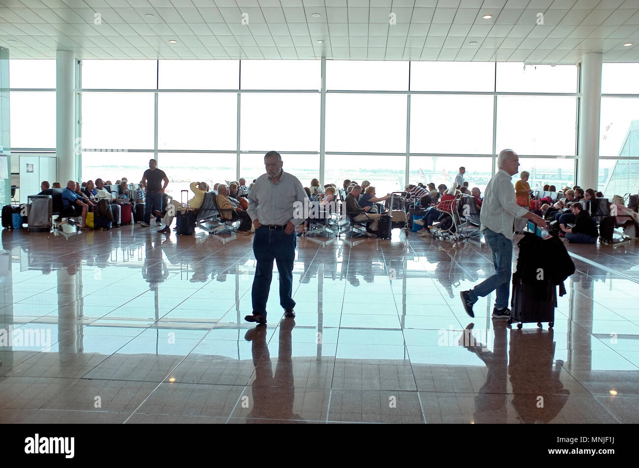 I passeggeri all'aeroporto di Barcellona in attesa per i voli in partenza lounge Foto Stock