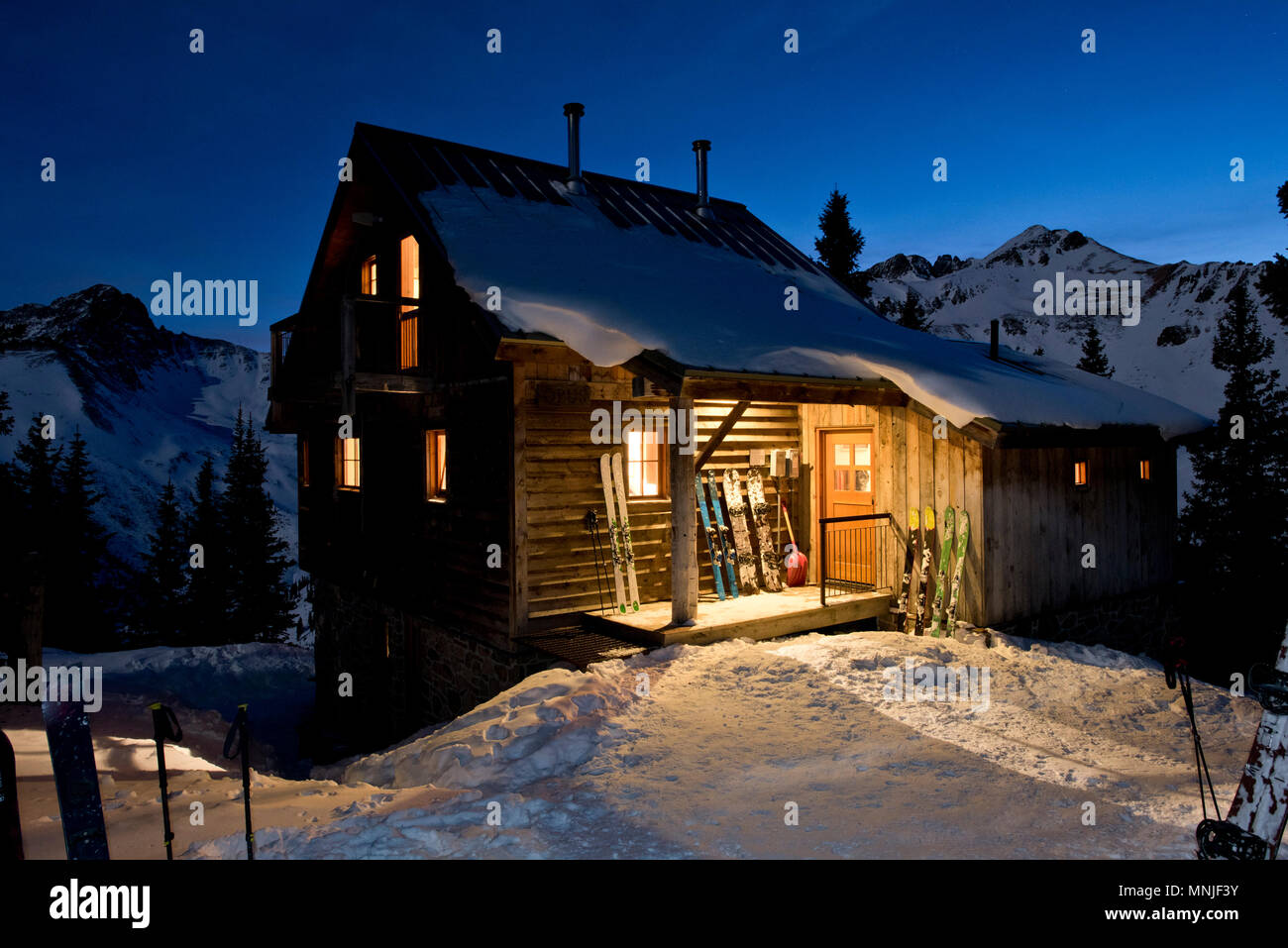 Esterno della capanna di legno in una notte d'inverno, San Juan Mountains, Ofir, Colorado, STATI UNITI D'AMERICA Foto Stock