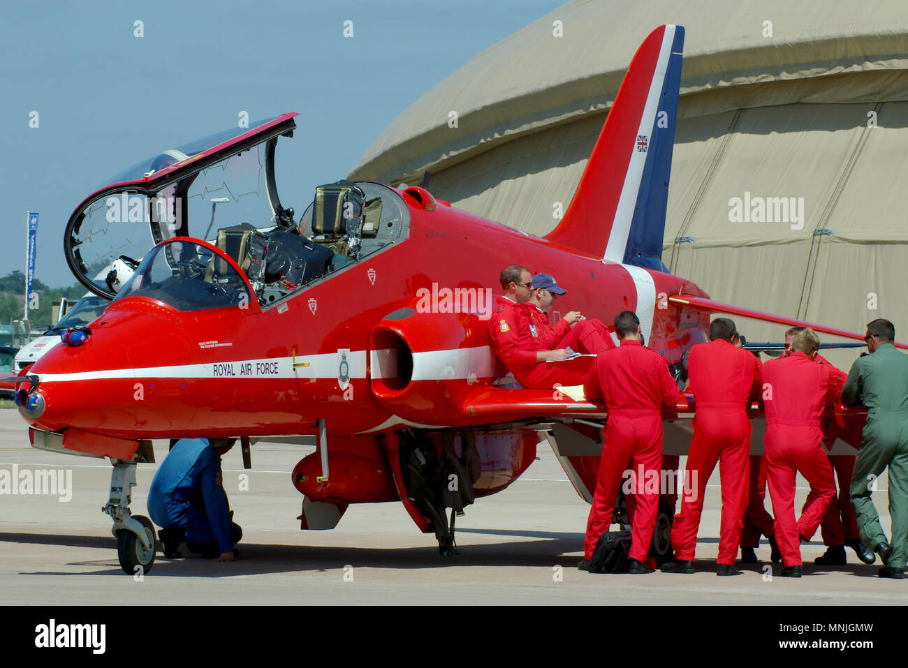 Red Arrows piloti che usano l'ala di un aereo jet Hawk T1 della Royal Air Force RAF Red Arrows per addestrare per un'esibizione in un airshow. Ingegneri Blues che lavorano Foto Stock