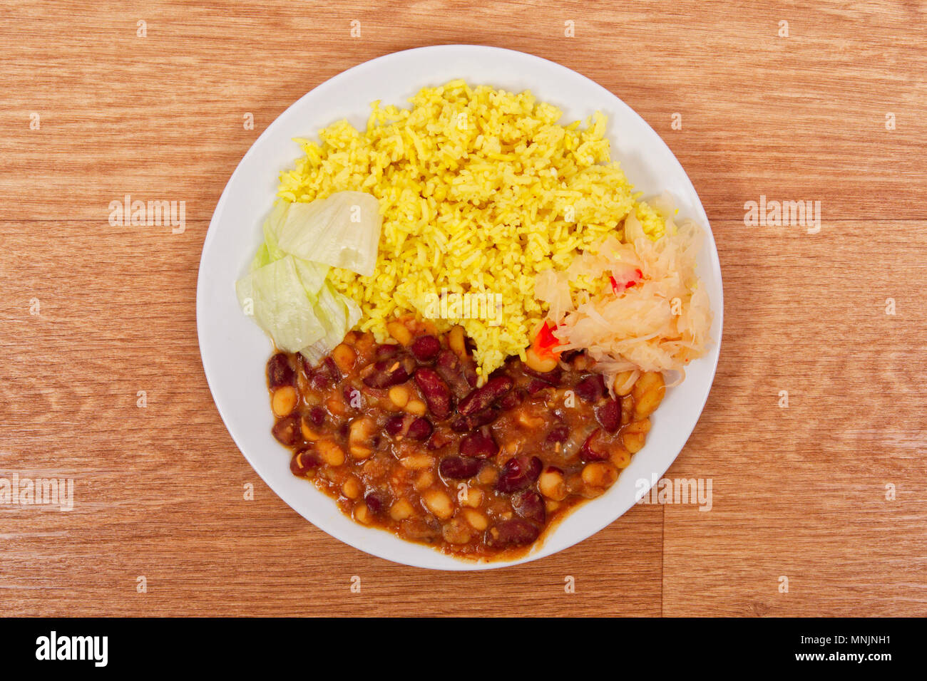 Fagioli rossi con riso al curry su un tavolo di legno Foto Stock