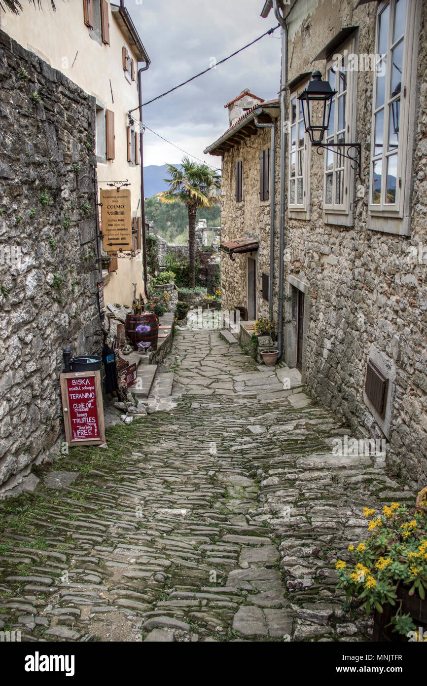 Hum, Istria centrale, Croazia - liquori, olio d'oliva, tartufi e di altre merci visualizzate in un negozio di souvenir collocato in un acciottolato strada stretta Foto Stock