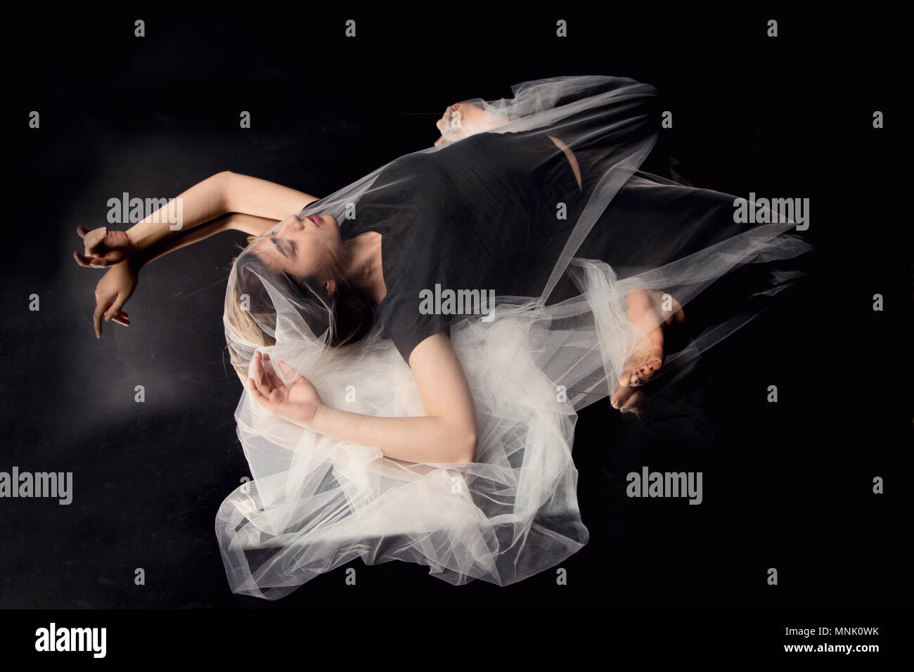 Giovane ballerino femmina coperti in tulle bianco sullo specchio con sfondo scuro, Istanbul Foto Stock