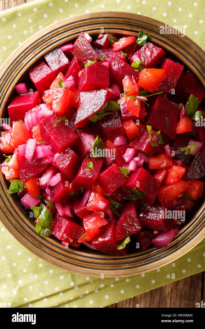 Ristoranti africani: marocchina Insalata di barbabietole con cipolle, pomodori e le erbe vicino sul tavolo. Verticale in alto vista da sopra Foto Stock