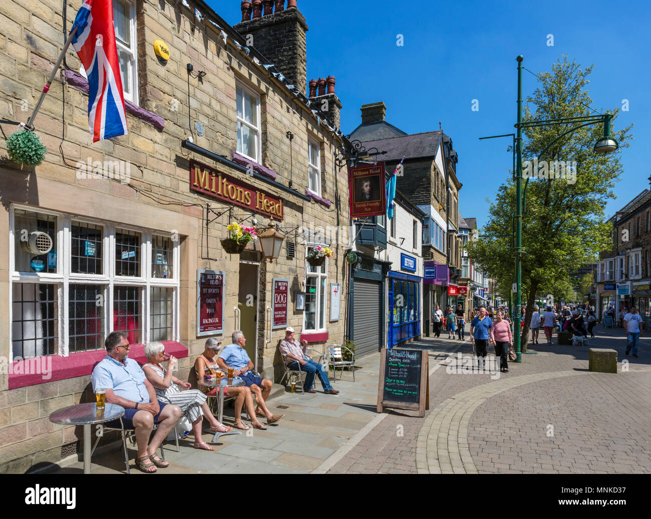 La gente seduta al di fuori della testa Miltons pub sulla molla giardini nel centro della città, Buxton, Derbyshire, England, Regno Unito Foto Stock