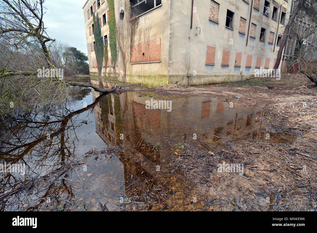 La riflessione di un villaggio abbandonato edificio nel grande pozza di acqua in Italia Foto Stock