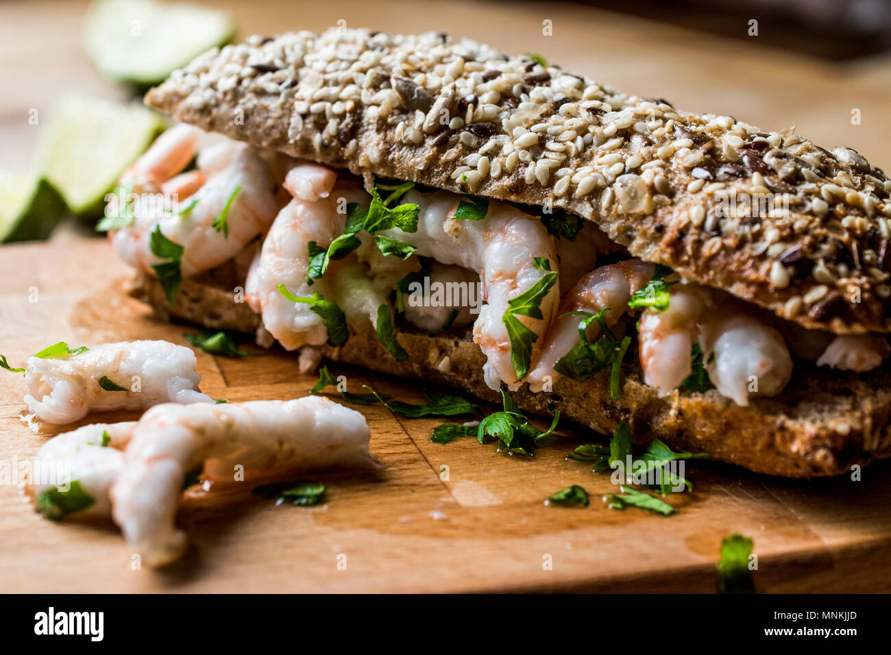 Sandwich di gamberi con calce sulla superficie di legno. Un fast food concept. Foto Stock