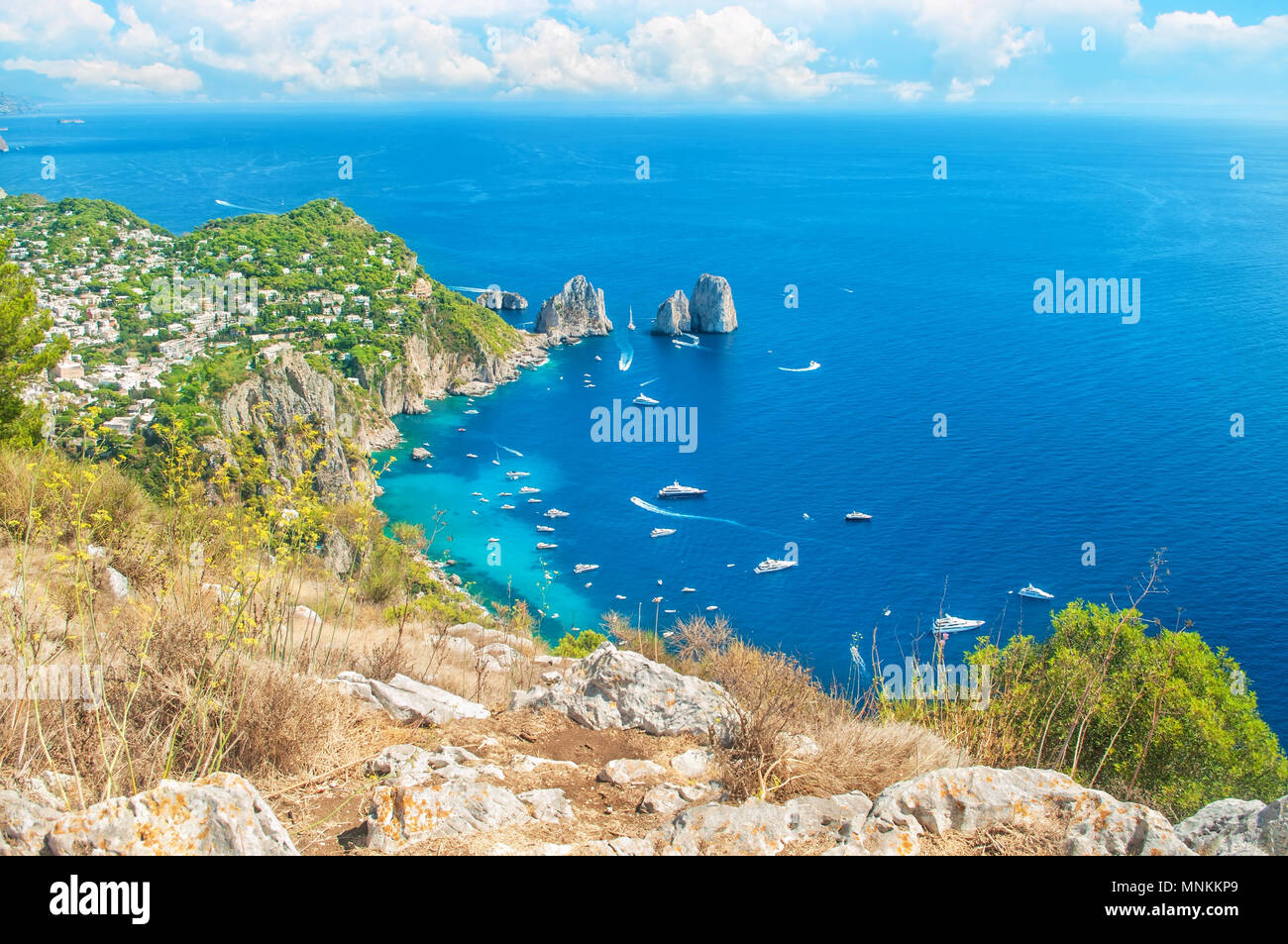 Bellissima vista della città di Capri e barche attorno ai Faraglioni dalla sommità del monte Solaro su soleggiate giornate estive, Capri, Italia Foto Stock