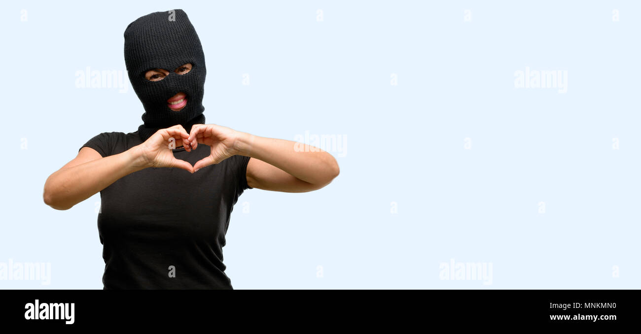 Ladro terrorista donna che indossa passamontagna maschera da sci che mostra  felice amore con le mani