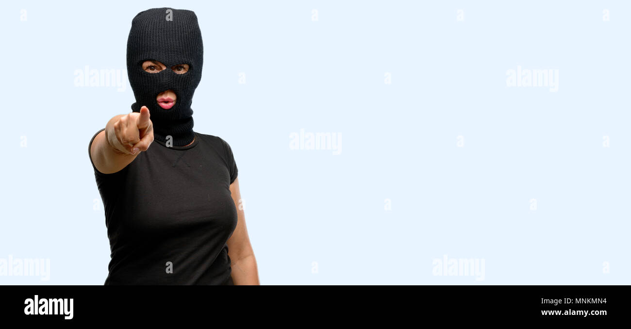Ladro terrorista donna che indossa passamontagna maschera da sci rivolta  verso la parte anteriore con il dito isolato sfondo blu Foto stock - Alamy