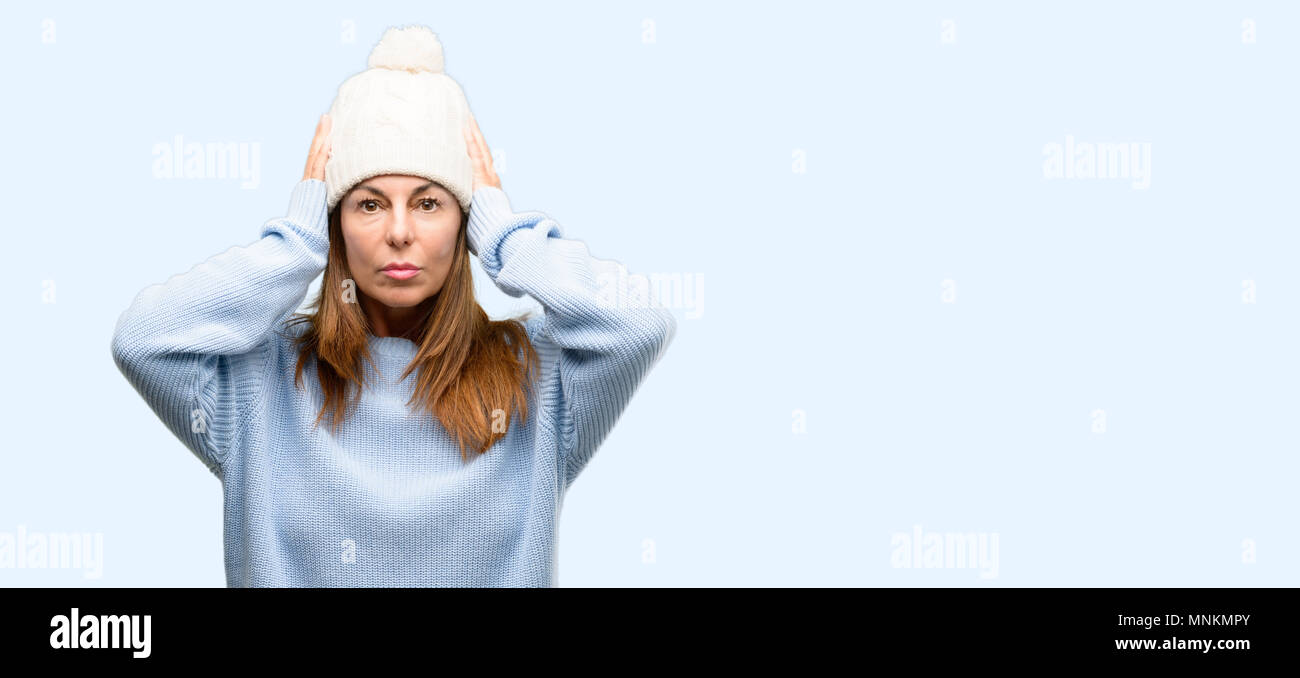 Medioevo donna che indossa la lana Cappello invernale di copertura ignorando le orecchie fastidioso rumore forte, tappi orecchie per evitare di sentire il suono. Rumorosa la musica è un problema. isol Foto Stock