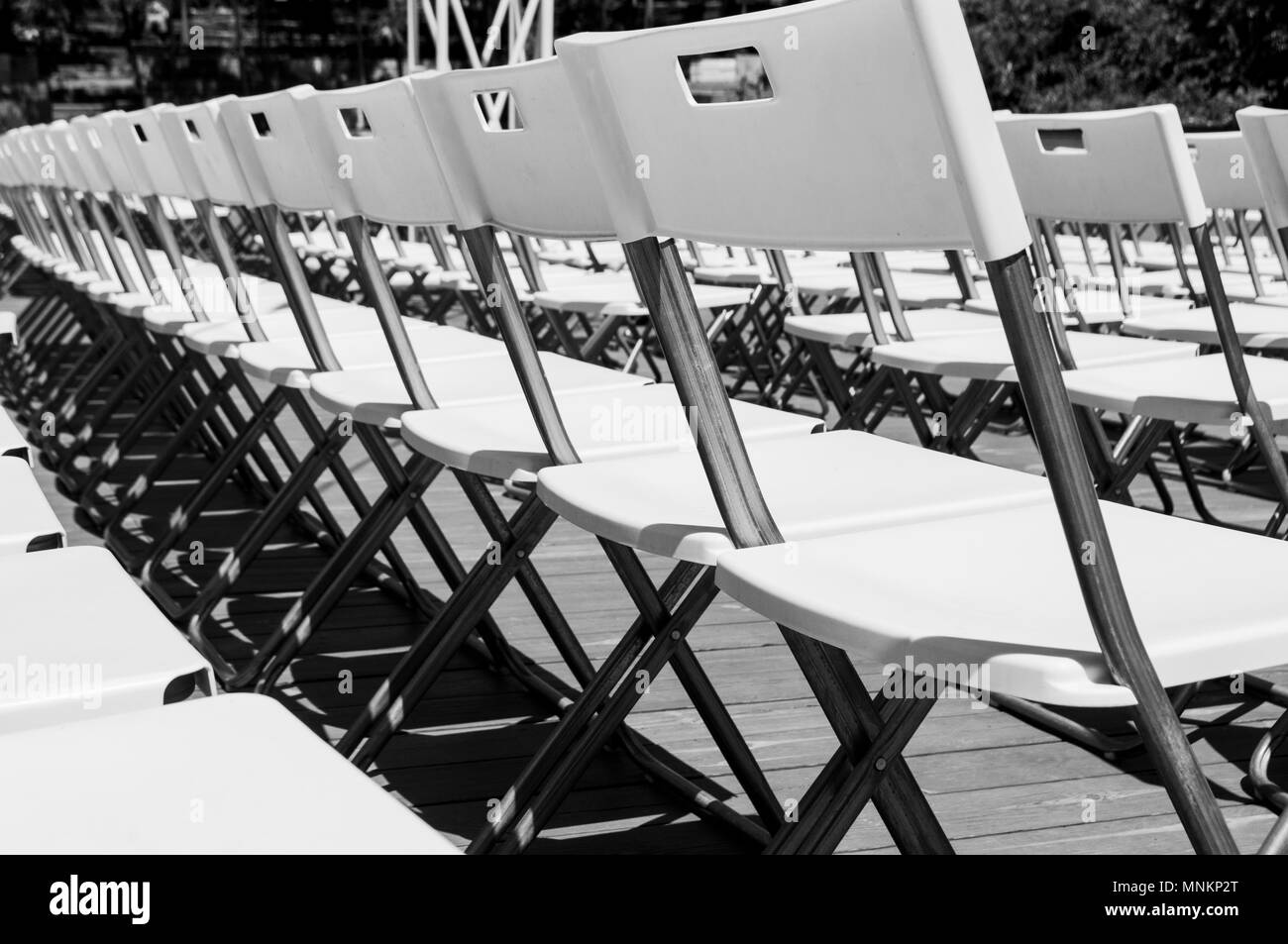 Immagine minimalista di righe di vuoto bianco sedie pieghevoli in un teatro estivo. Foto Stock