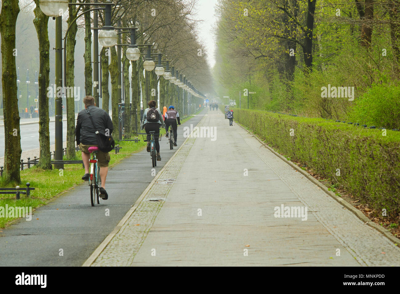 Berlino, Germania - 14 Aprile 2018: bicicletta lane con i ciclisti e marciapiede lungo il 17 giugno Street e il giardino delle rose im Tiergarten di Berlino Foto Stock