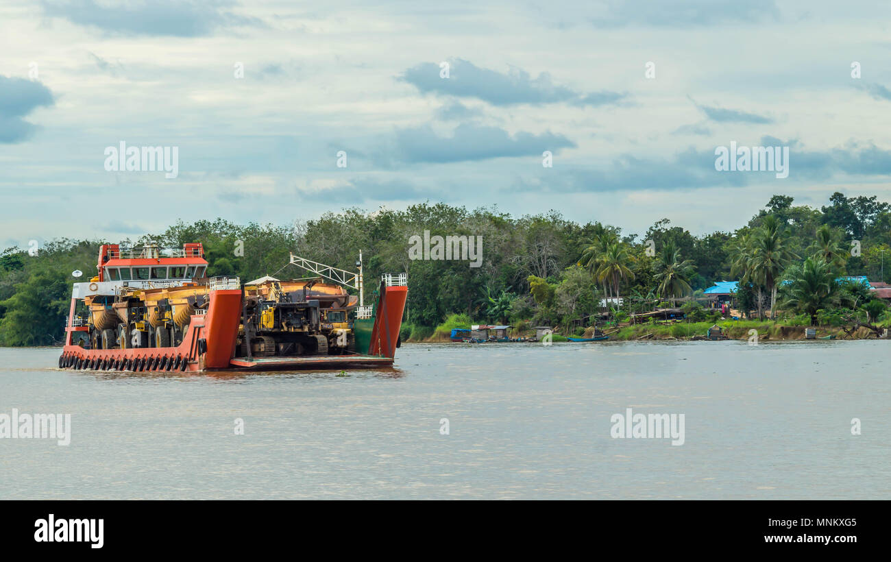 Nave piena di pesanti macchinari per industria mineraria crociera sul fiume Mahakam, Borneo, Indonesia Foto Stock