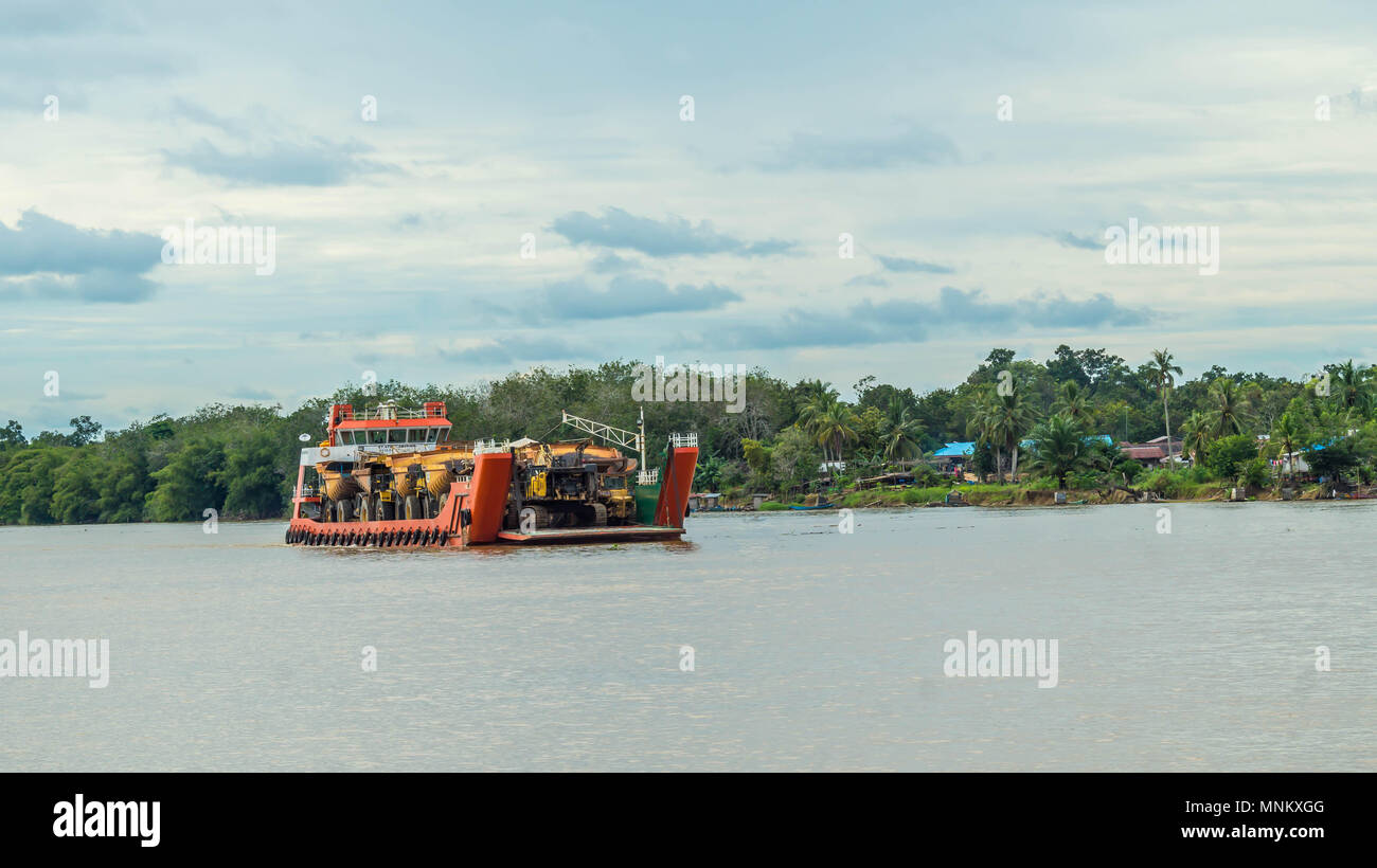 Nave piena di pesanti macchinari per industria mineraria crociera sul fiume Mahakam, Borneo, Indonesia Foto Stock