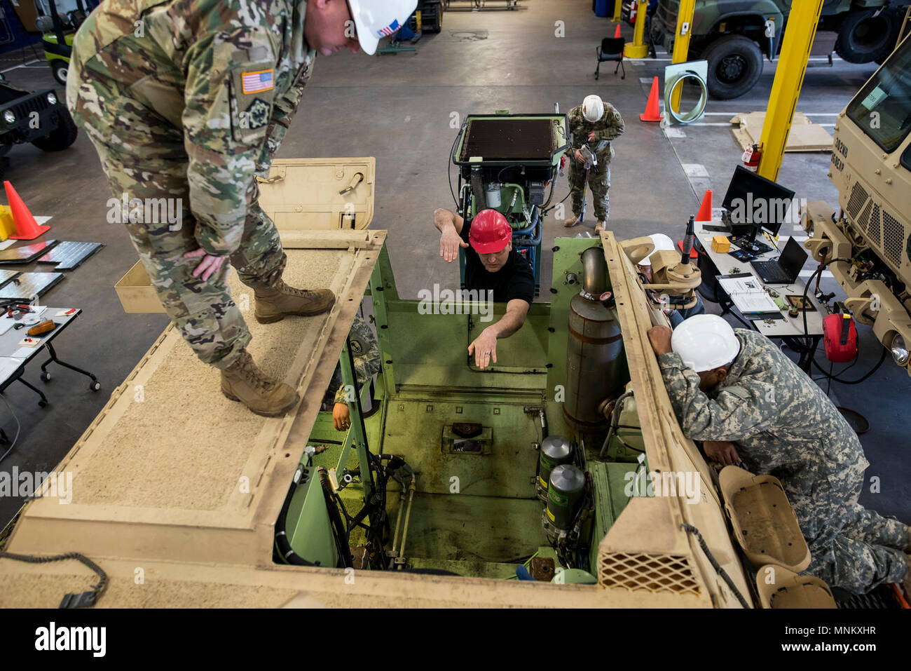 Herbert verde (centro), istruttore di manutenzione per la 99th disponibilità divisione, dirige U.S. La riserva di esercito meccanica da il duecentesimo della Polizia Militare il comando come il motore pack torna in un M1117 corazzati di sicurezza del veicolo (ASV) durante un corso di manutenzione ospitati in Schenectady, New York, 14 marzo, 2018. Questo è il primo corso di manutenzione negli Stati Uniti La riserva di esercito progettato specificamente per l'ASV, che ha i componenti idraulici e le procedure di manutenzione che sono a differenza della maggior parte degli altri veicoli militari. L'ASV è progettato per resistere all'impatto di bombe su strada durante il funzionamento in ambiente urbano environme Foto Stock