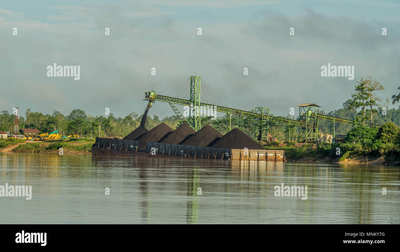 Intrusione viene caricata con carbone utilizzando il convogliatore in scorte sulla riva del fiume Foto Stock