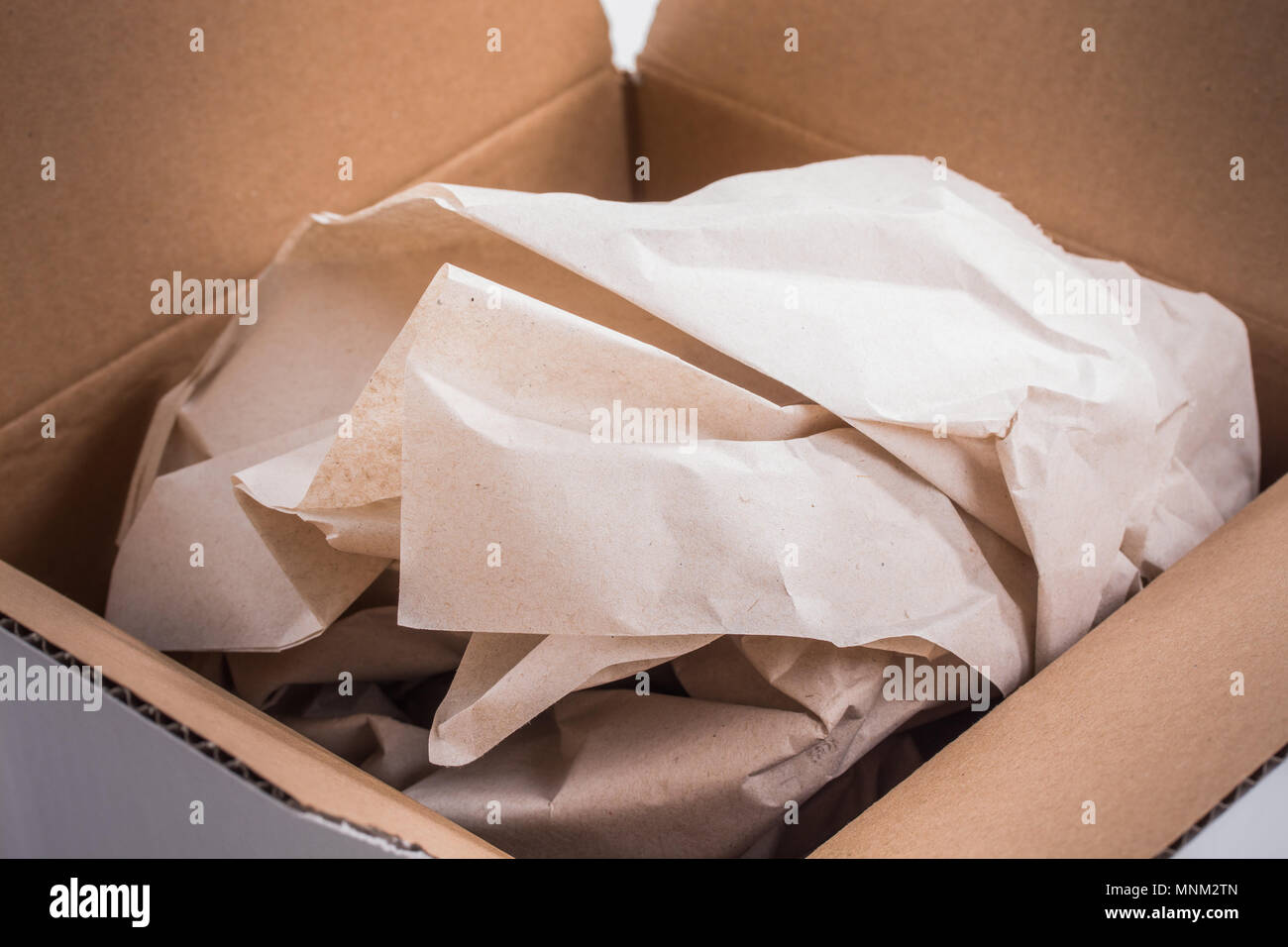 Vista nella confezione di spedizione, contenuti coperti da carta di materiale di riempimento Foto Stock