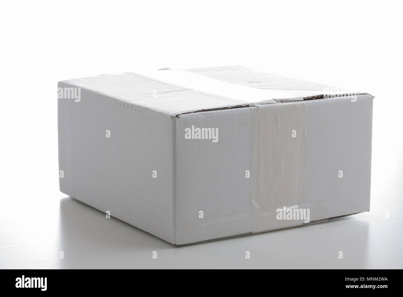 Scatola di cartone bianco con strisce adesive per lo shopping online su sfondo bianco Foto Stock