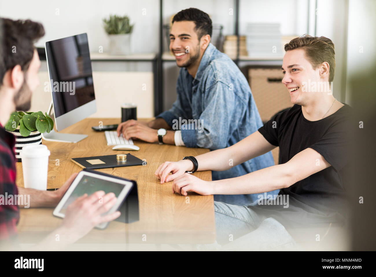 Sorridente giovani investitori utilizzando Internet per costruire la loro azienda start-up Foto Stock