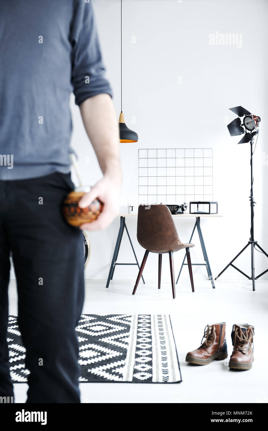 Piatto bianco con scrivania, lampada, scarpe maschio sdraiato sul pavimento Foto Stock