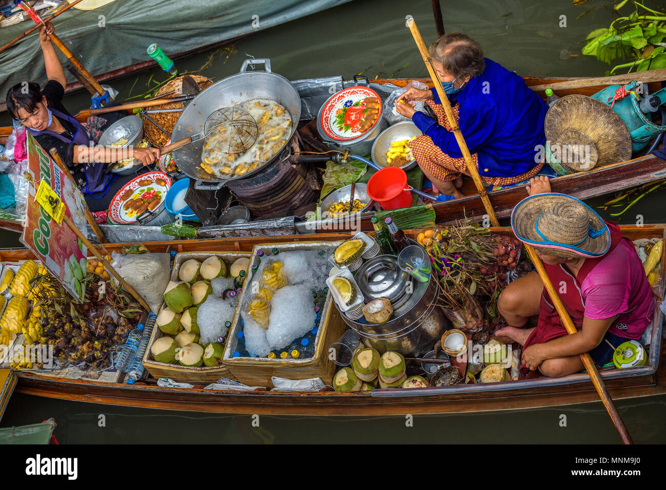 I venditori locali presso un mercato galleggiante in Thailandia Foto Stock