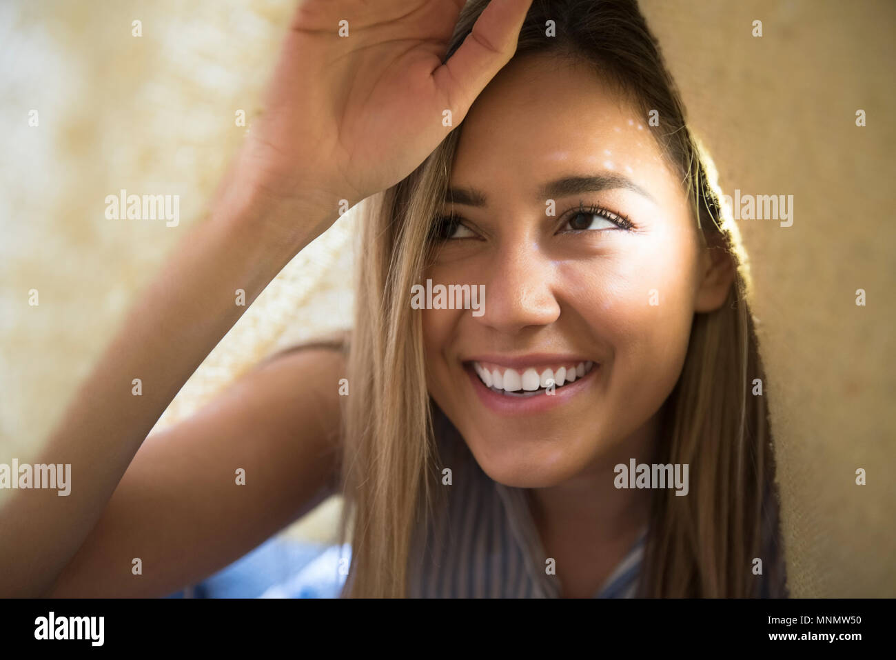Sorridente giovane donna sotto coperta Foto Stock