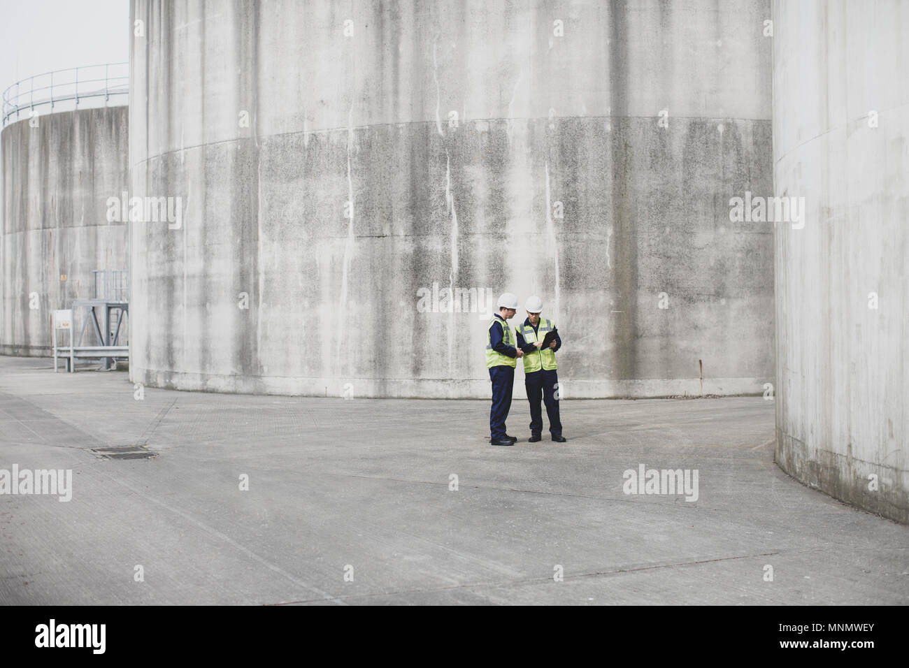 I lavoratori industriali utilizzando una tavoletta digitale sul sito Foto Stock
