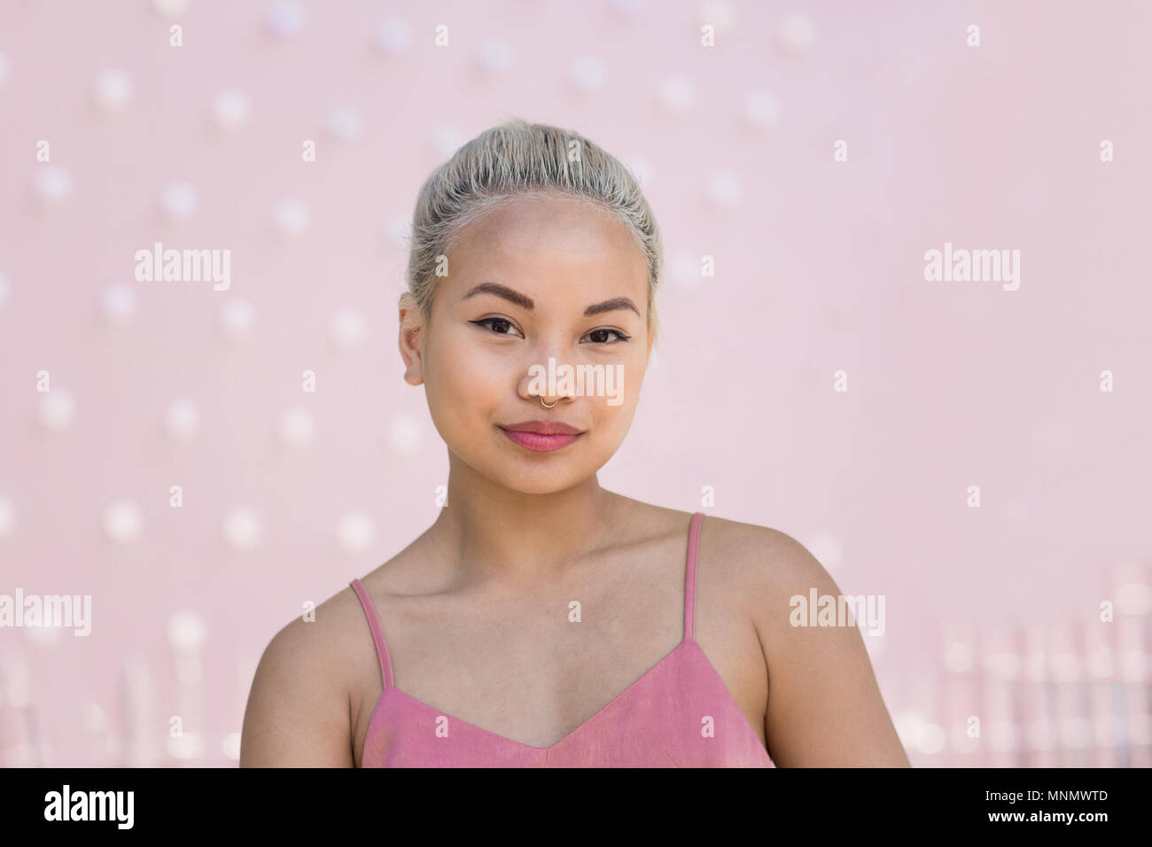 Ritratto di giovane femmina adulta con sfondo rosa Foto Stock