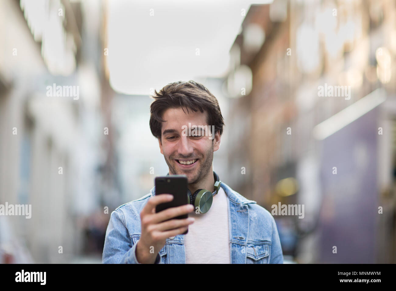 Giovani maschi adulti ridere per smartphone Foto Stock