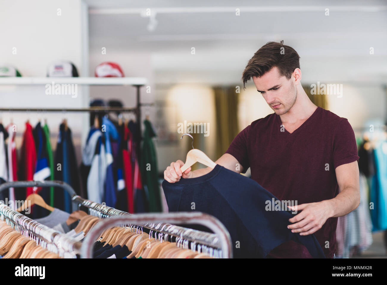 Giovani maschi adulti vestiti shopping Foto Stock