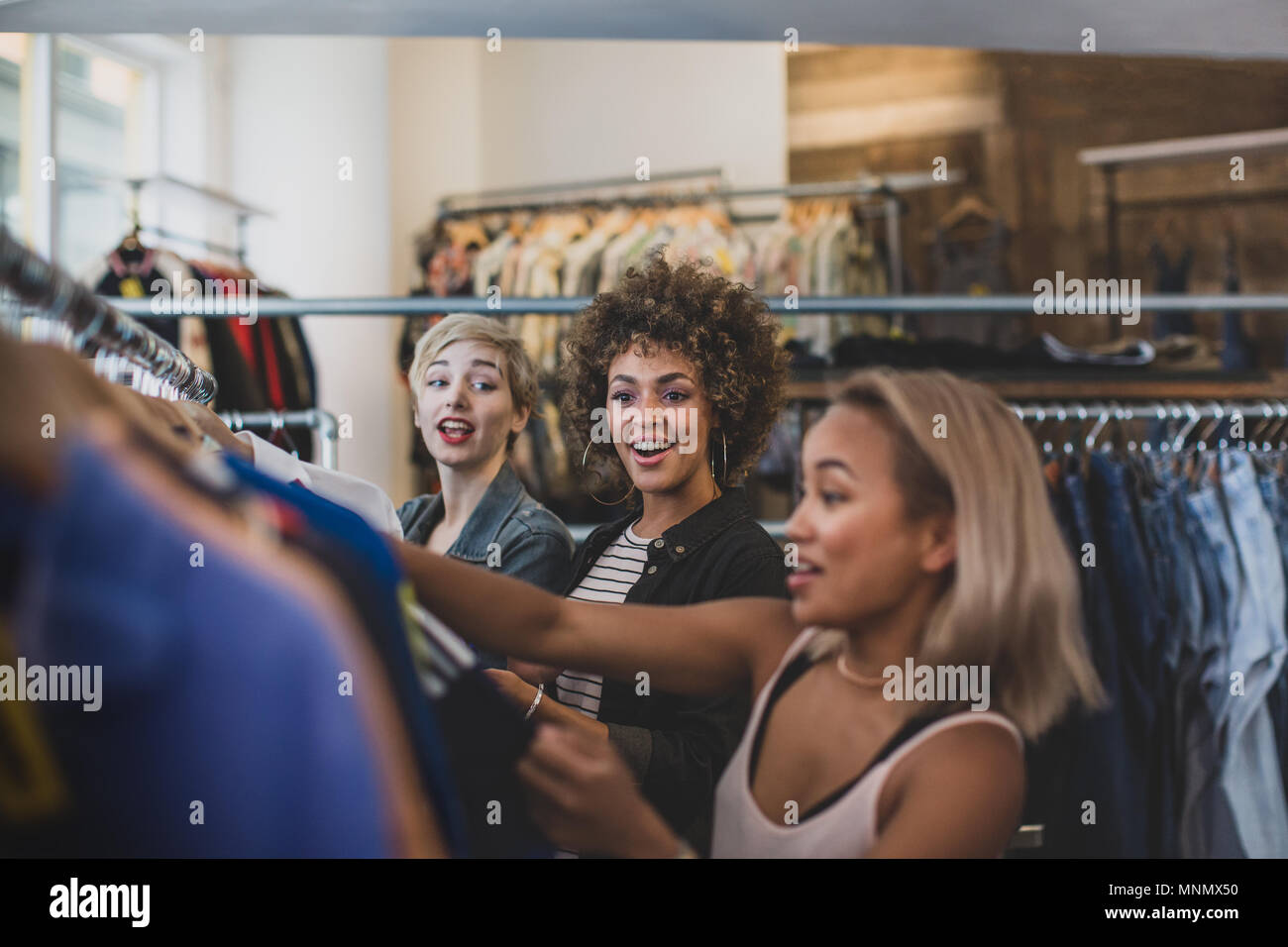 Femmina millenario amici shopping in un vintage negozio di abbigliamento Foto Stock