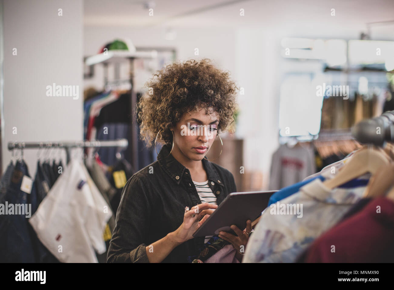 Store manager utilizzando digitale compressa in un negozio di abbigliamento Foto Stock