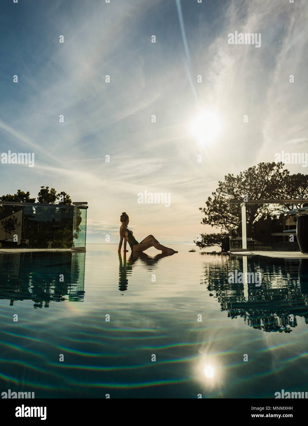 La donna a rilassarci in piscina Foto Stock