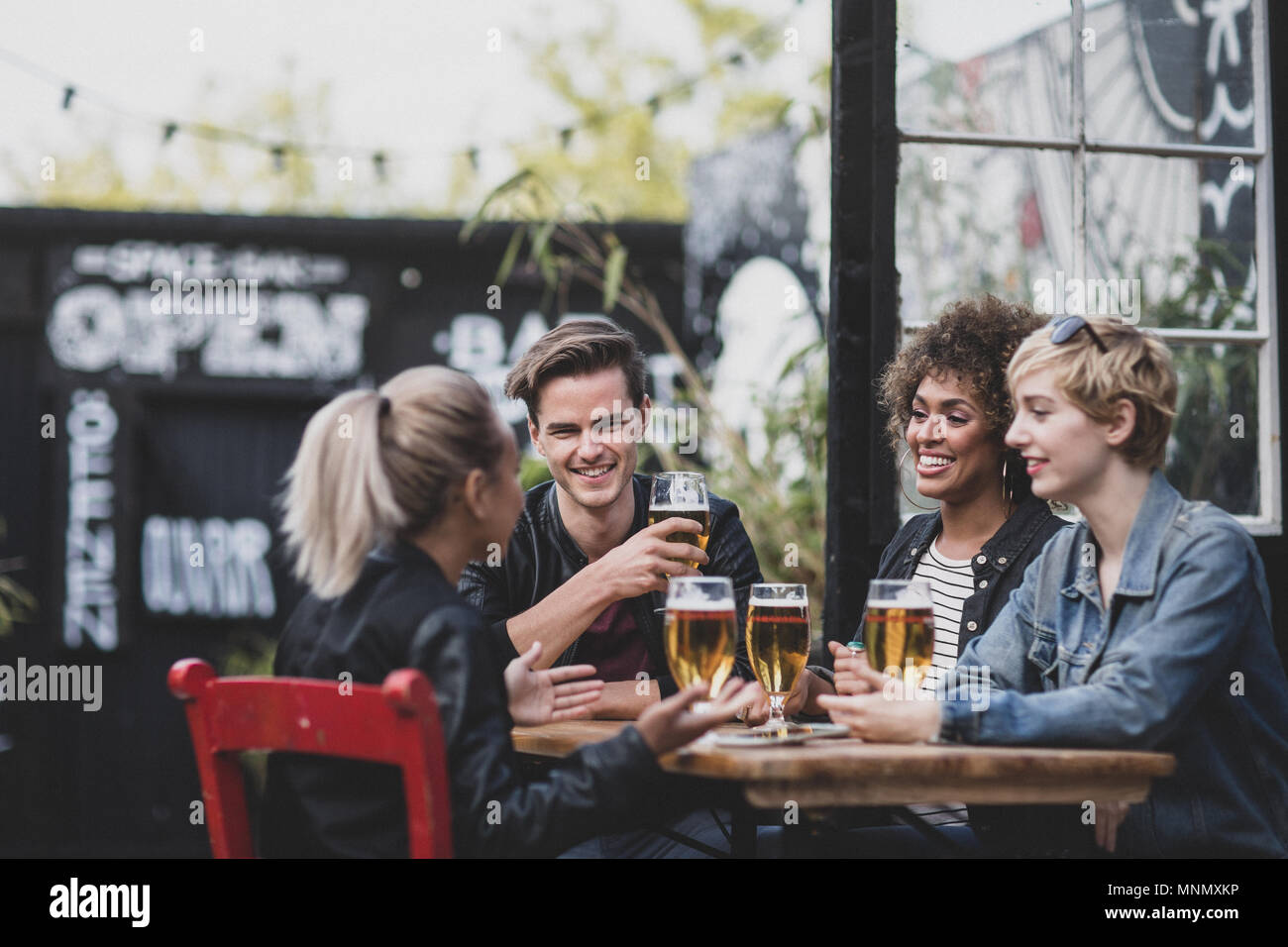 Gli amici a bere in un bar all'aperto in estate Foto Stock