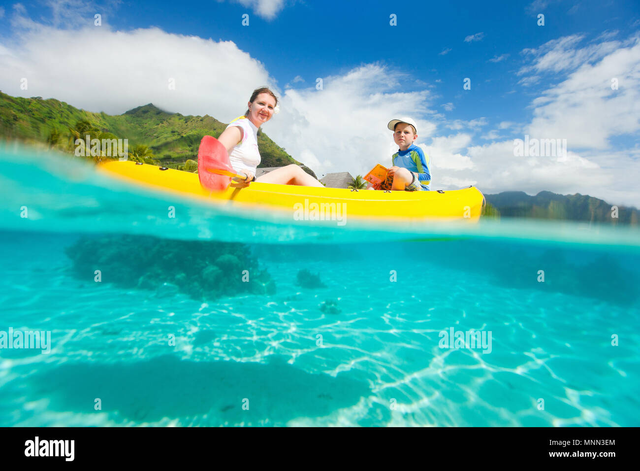 Madre e figlio kayak in una laguna tropicale Foto Stock