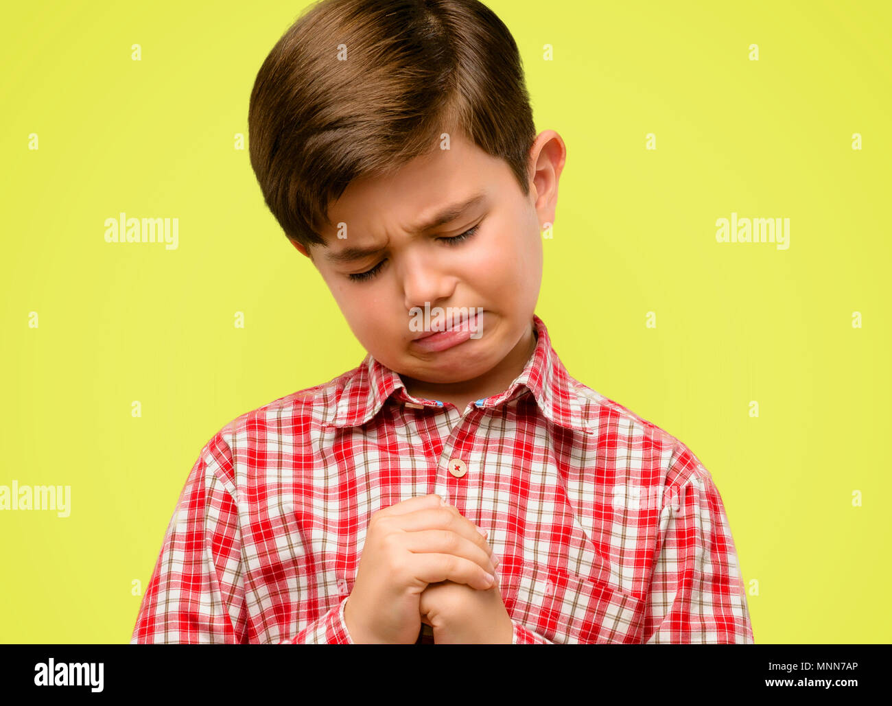 Bel bimbo bambino con occhi verdi di piangere premuto pieno di tristezza  che esprimono triste emozione su sfondo giallo Foto stock - Alamy