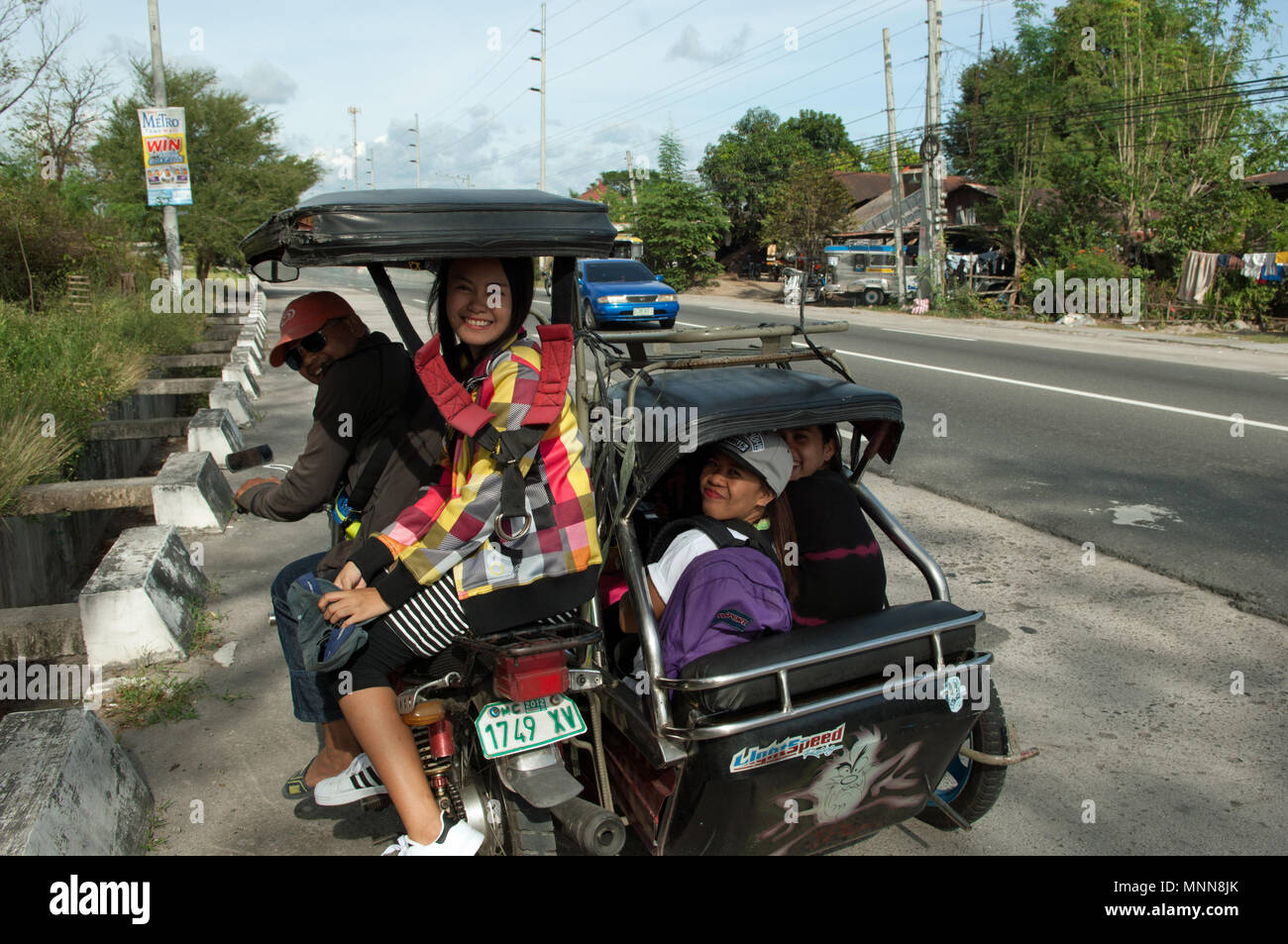Un triciclo a motore con quattro passeggeri Foto Stock