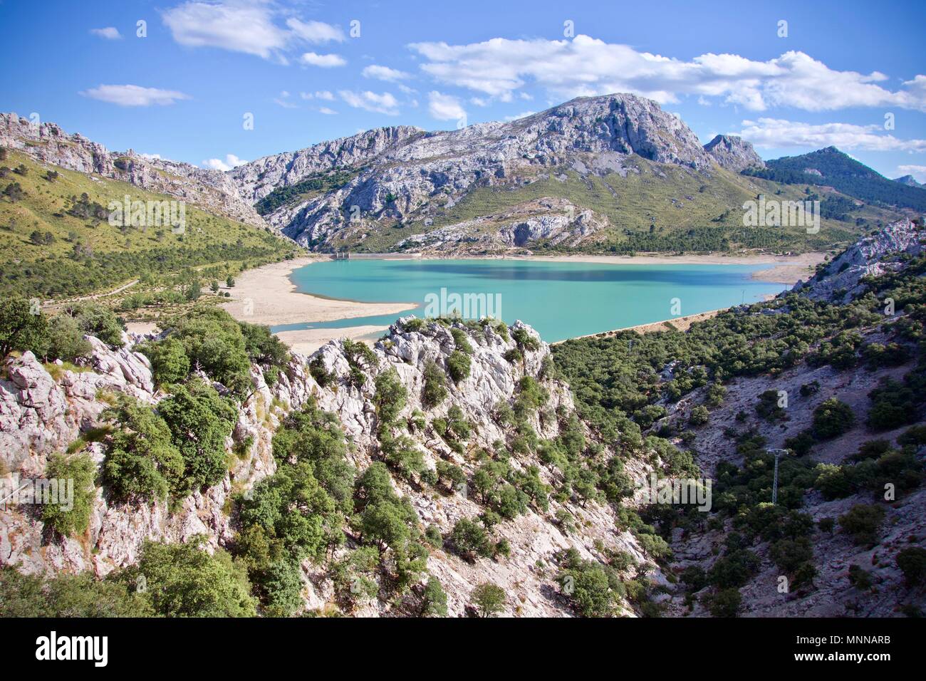 Vista aerea del Embalse de Cuber all aperto in una valle con un serbatoio di acqua in background Foto Stock