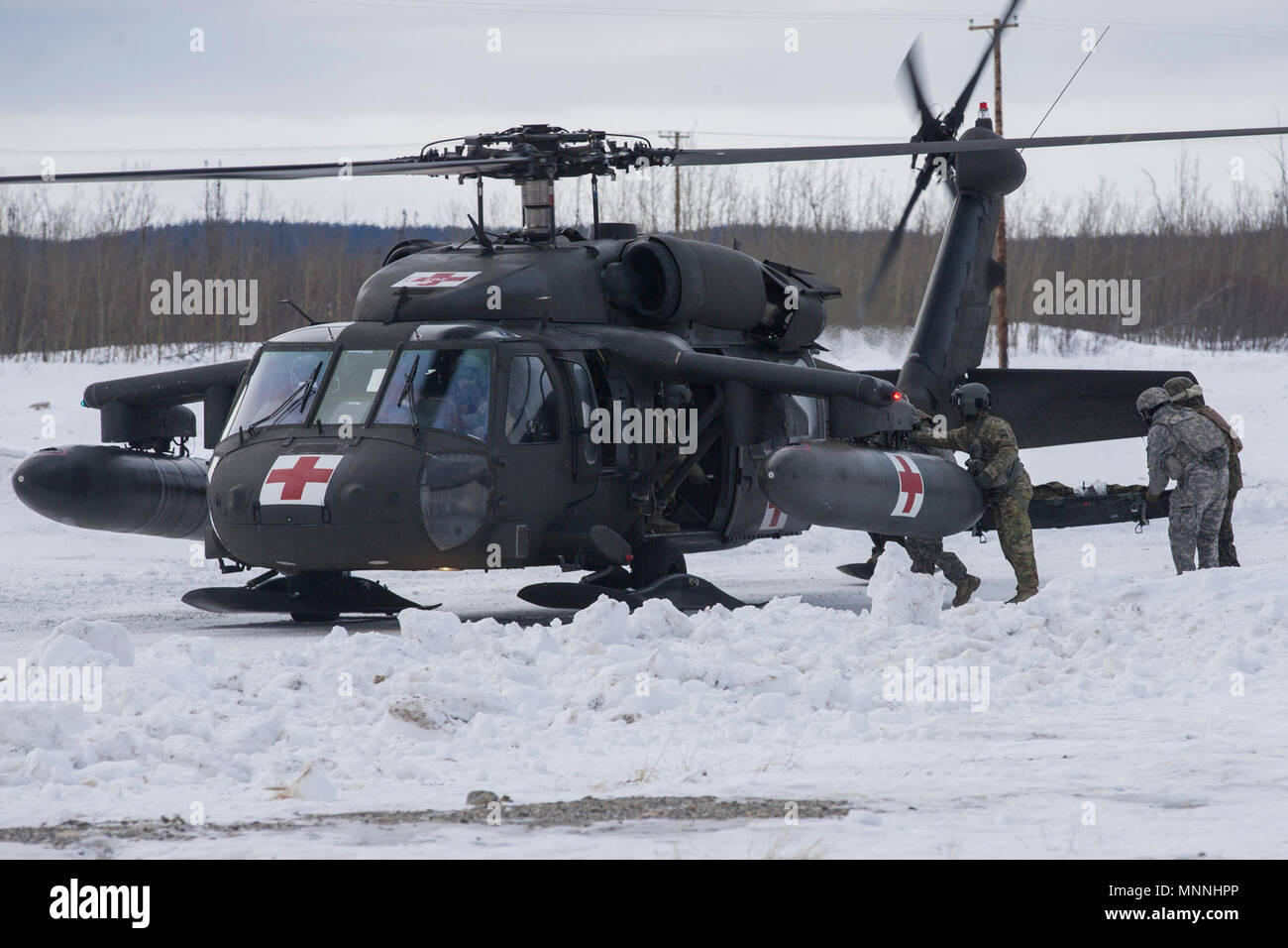 Marines con logistica di combattimento del reggimento di 25, 2° Marine Logistics Group e soldati con xxi Reggimento di Fanteria, XXV divisione di fanteria, effettuare una simulazione di incidente a bordo di un esercito UH-60 Black Hawk elicottero con 1° Battaglione, 52nd reggimento di aviazione durante l'esercizio Arctic Edge 18, a Fort Greely, Alaska, Marzo 15, 2018. Arctic Edge 18 è una biennale su grande scala, joint-esercizio che prepara e prove il militare degli Stati Uniti è la sua capacità di operare tatticamente nel freddo estremo-Condizioni meteorologiche rilevate in ambienti artici con più di 1500 partecipanti dalla Air Force, esercito, Guar della costa Foto Stock