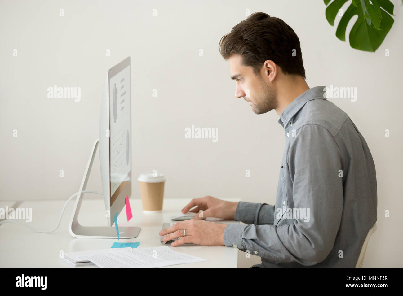 Imprenditore focalizzato lavora su computer con le statistiche del progetto, Foto Stock