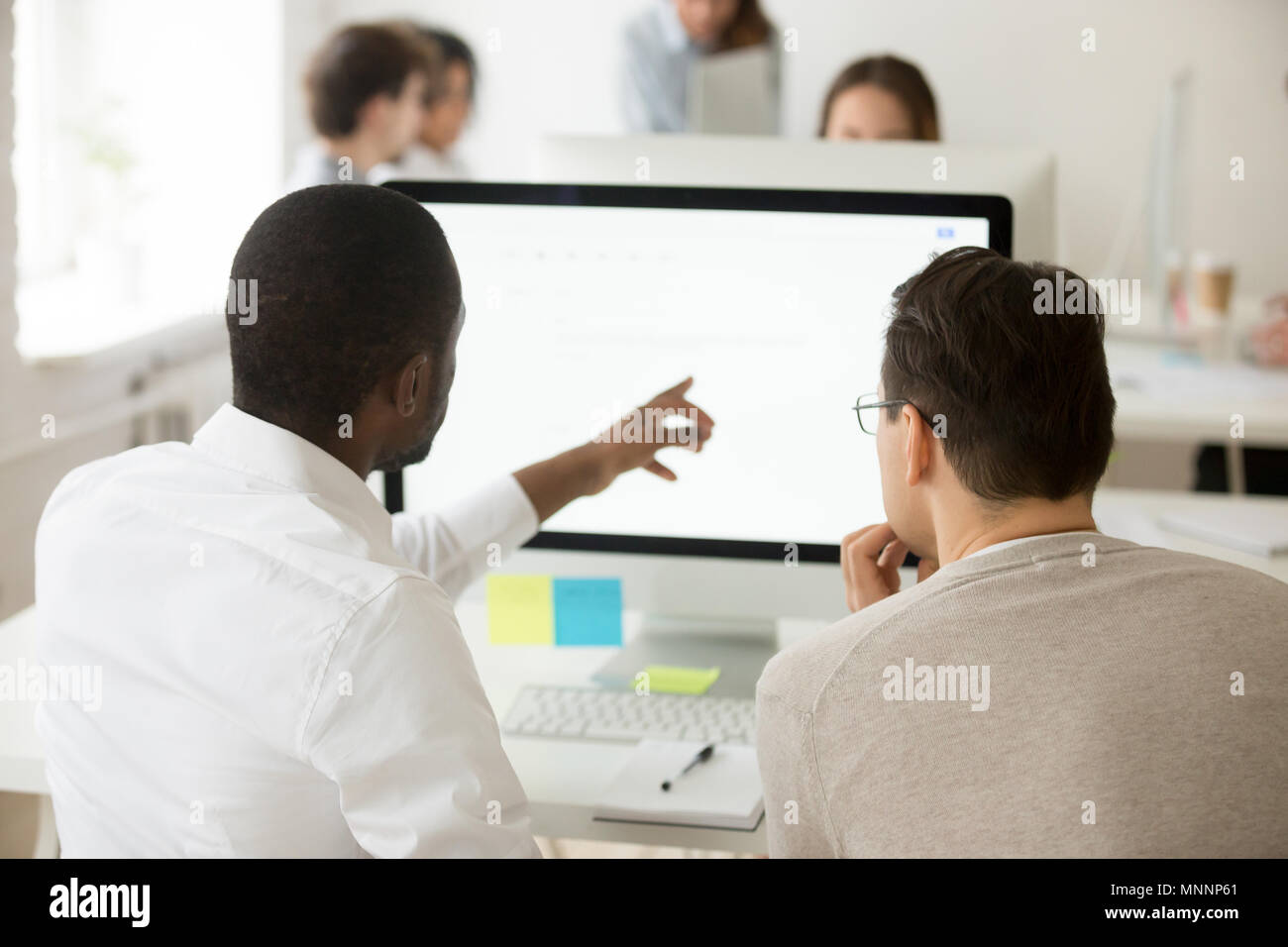 African team leader spiegando collega applicazione aziendale u Foto Stock