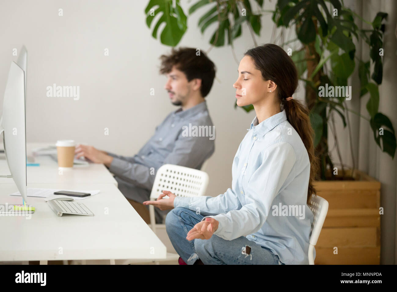 Memore calma giovane donna prendendo pausa in ufficio per la meditazione Foto Stock