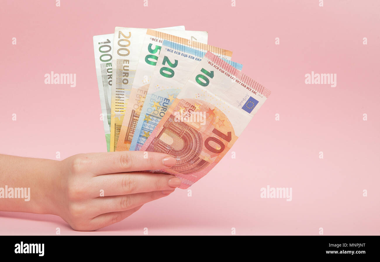 Le banconote in euro i soldi in mani femminili su sfondo rosa. Il concetto  di Business e Instagram Foto stock - Alamy