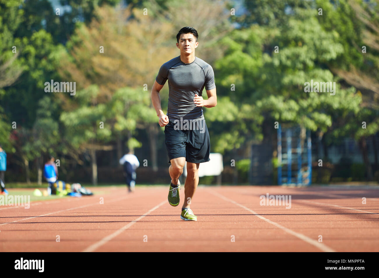 Giovane uomo asiatico atleta maschio esegue la formazione esercita sulla via. Foto Stock