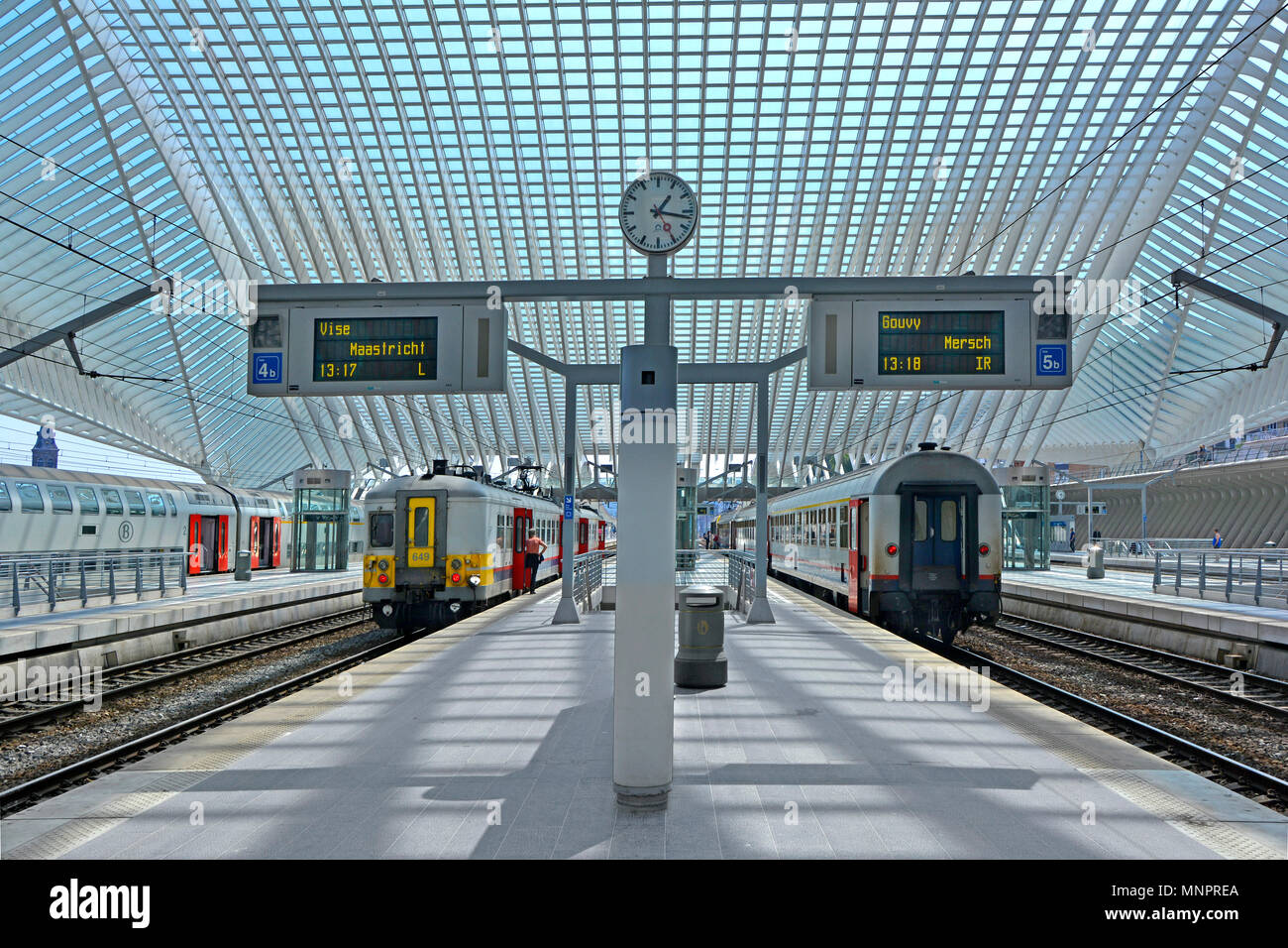 Architettura simmetrica equilibrio del moderno trasporto pubblico Liege Belgio UE stazione ferroviaria stazione ferroviaria clock & grande tetto di vetro che coprono i treni Foto Stock