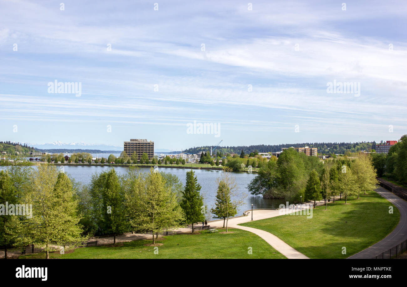 Olympia, Washington / STATI UNITI D'America - 5 Maggio 2018: persone passeggiare e correre attraverso il Capitol Lake Park con le Montagne Olimpiche visibile in distanza. Foto Stock