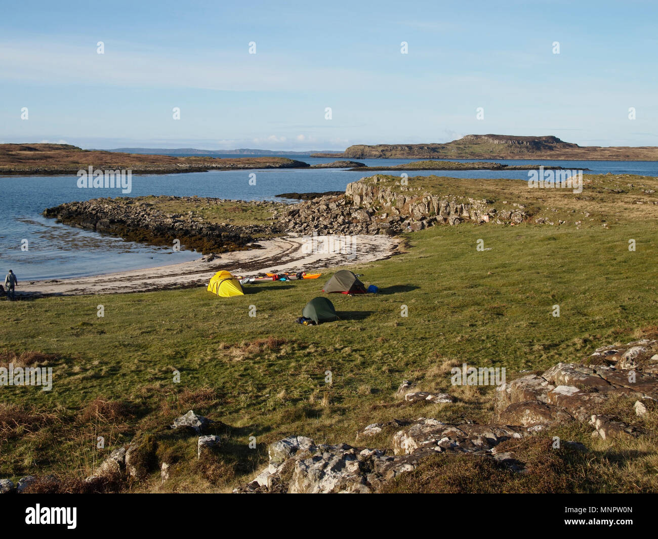 Campeggio selvaggio sulla costa sud di Ulva, Scozia, con poco Colonsay dietro Foto Stock
