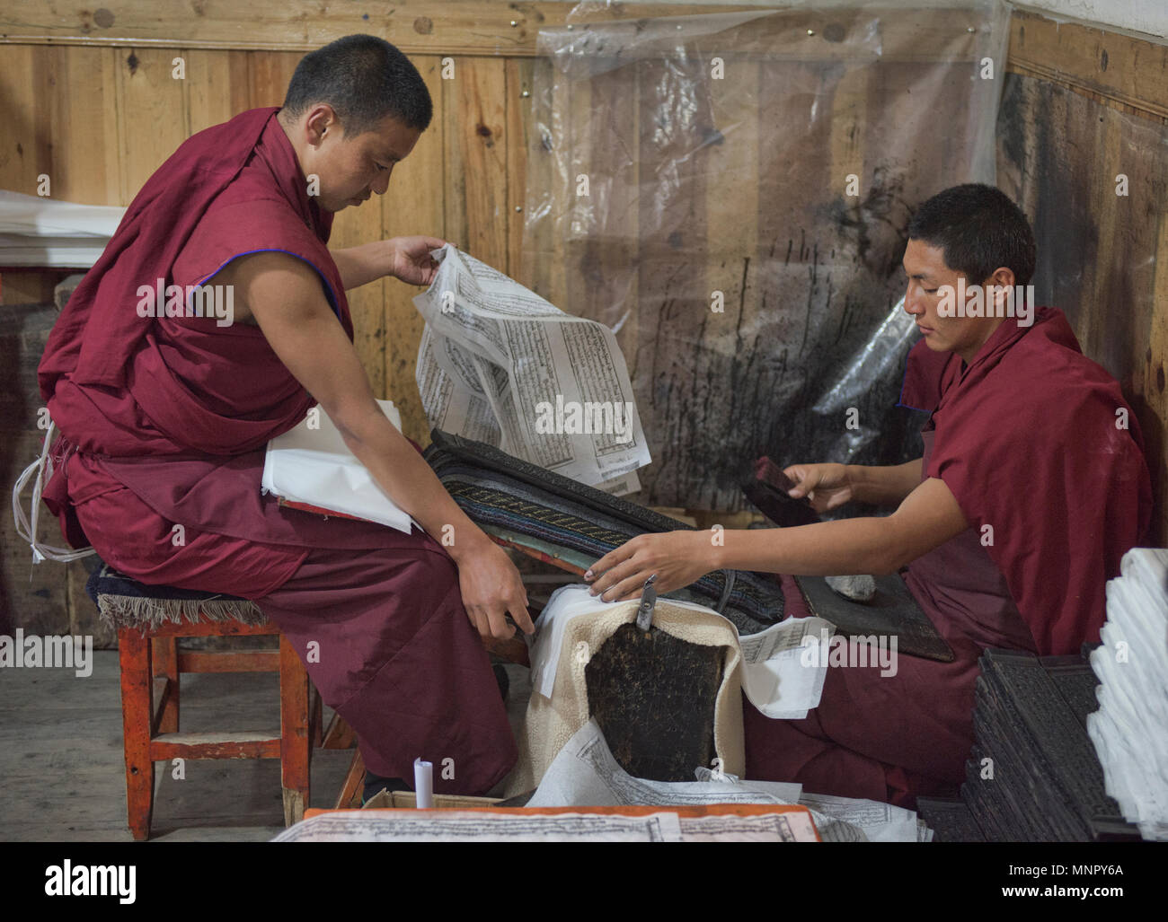 I monaci rendendo la carta a mano scritture e stampe di woodblock all'interno della sacra Scrittura Bakong Stampa Monastero a Dege, Sichuan, in Cina Foto Stock